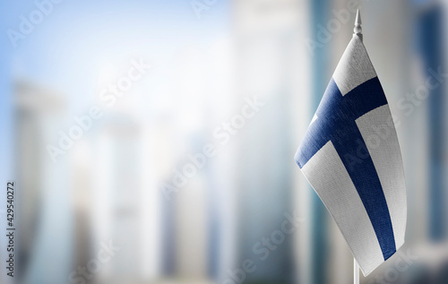 A small flag of Finland on the background of a blurred background photo