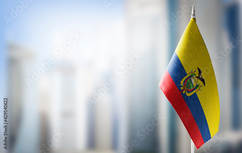 A small flag of Ecuador on the background of a blurred background