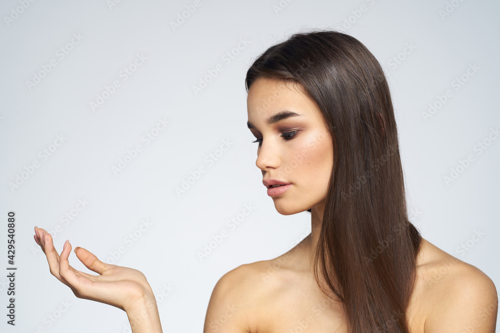 Woman with long hair bared shoulders clean skin body care light background Woman with long hair bared shoulders clean skin body care light background