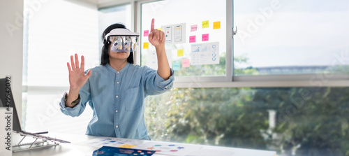asian woman using augmented reality (ar) and Mixed reality glasses simulation meeting and working with hologram over table at office.virtual reality development process concept photo