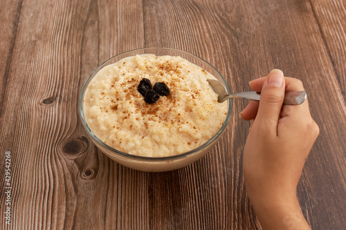 Tazón de arroz con leche sobre mesa de madera. Postre delicioso hecho en casa, saludable.