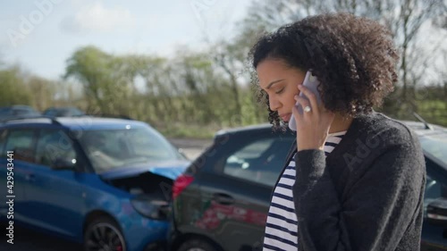 Female Driver Contacting Car Insurance Company On Mobile Phone After Road Traffic Accident