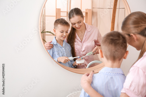 Mother and little son brush...