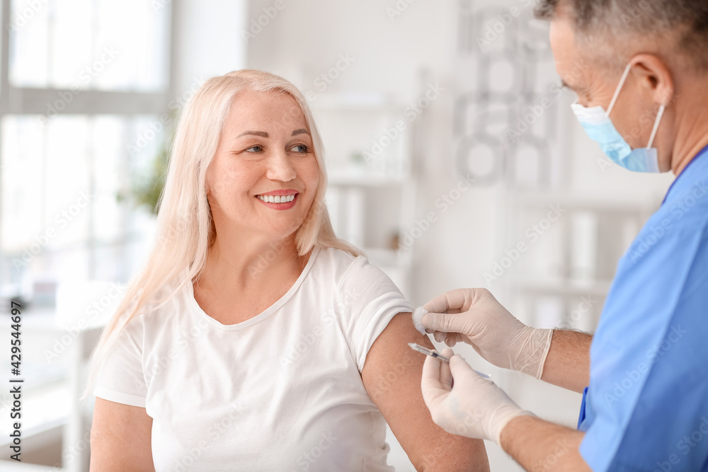 Doctor vaccinating patient in clinic Doctor vaccinating patient in clinic