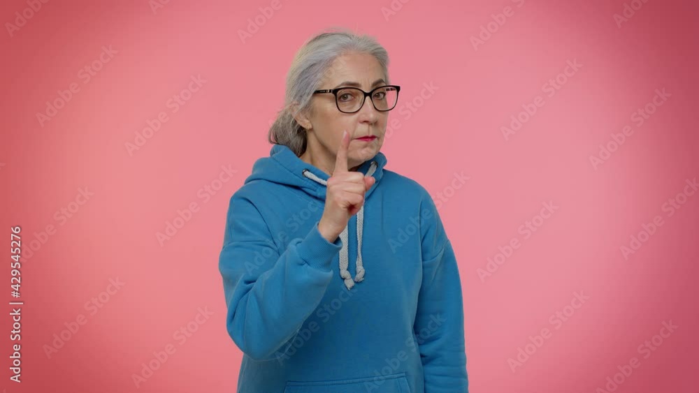 Senior old granny woman in glasses shakes finger and saying no, be careful, scolding, giving advice to avoid danger mistake, disapproval sign. People lifestyle. Elderly mature grandmother pensioner Senior old granny woman in glasses shakes finger and saying no, be careful, scolding, giving advice to avoid danger mistake, disapproval sign. People lifestyle. Elderly mature grandmother pensioner