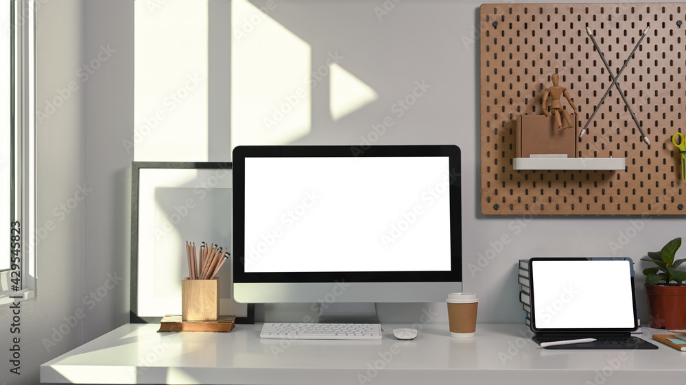 Comfortable workspace with computer, digital tablet and office supplies on white table. Comfortable workspace with computer, digital tablet and office supplies on white table.