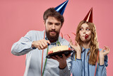 Party man and woman with cake on pink background corporate birthday