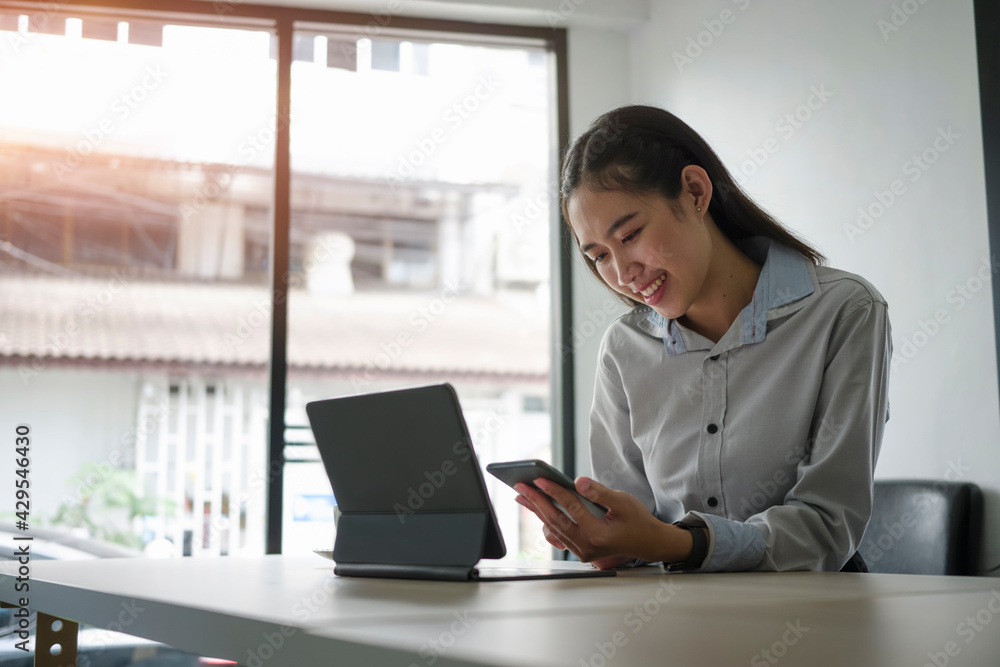 Happy businesswoman smiling and texting or massaging with her friends on mobile phone at office. Happy businesswoman smiling and texting or massaging with her friends on mobile phone at office.