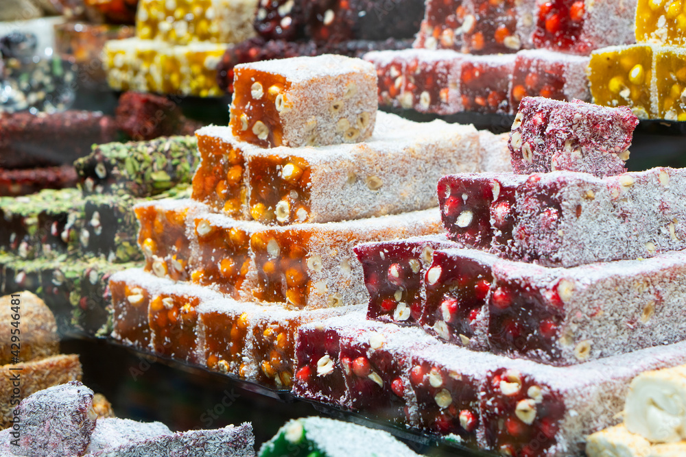 Fototapeta premium .Traditional oriental sweet pastry cookies, nuts, dried fruits, pastilles, marmalade, Turkish desert with sugar, honey and pistachio, in display at a street food market