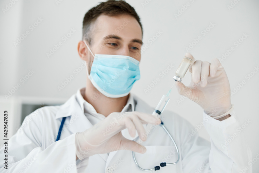 doctor in the laboratory holds a syringe in his hand medical mask vaccine liquid doctor in the laboratory holds a syringe in his hand medical mask vaccine liquid