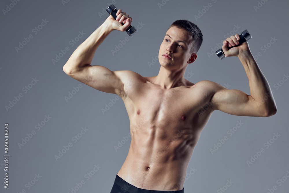 athletic muscular man with muscular body dumbbells in the hands of biceps workout