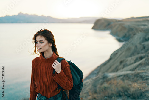 beautiful traveler with backpack in mountains on nature and high mountains sea sky
