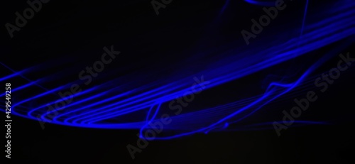 Closeup of Neon blue Spirograph geometric abstract pattern flowing in a isolated black background . Made using Long exposure technique, Light painting. Pendulum pattern.