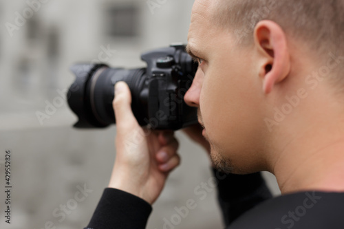 photography and hobby concept - close up back view of male photographer taking photo with modern dslr camera © Di Studio