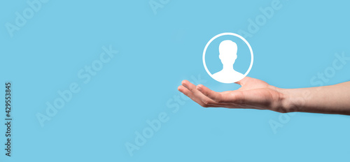 Hand holds user person icon interface on blue background.User symbol for your web site design, logo, app, UI.Banner