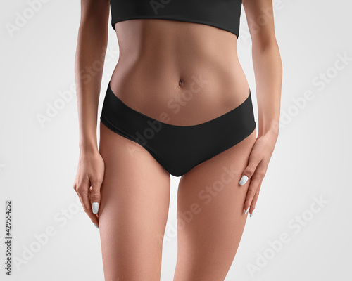 Mockup of black seamless panties on slim girl isolated on background in studio