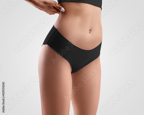Mockup of black seamless panties on slim girl isolated on background in studio © olegphotor