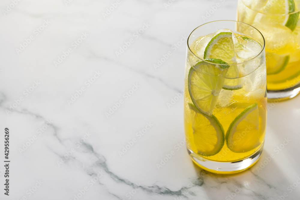 Two glasses of refreshing lemonade with lime and lemon. Copy space, marble background. Two glasses of refreshing lemonade with lime and lemon. Copy space, marble background.