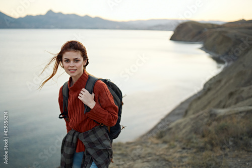 woman in a red sweater outdoors in the mountains fresh air sea mountains landscape