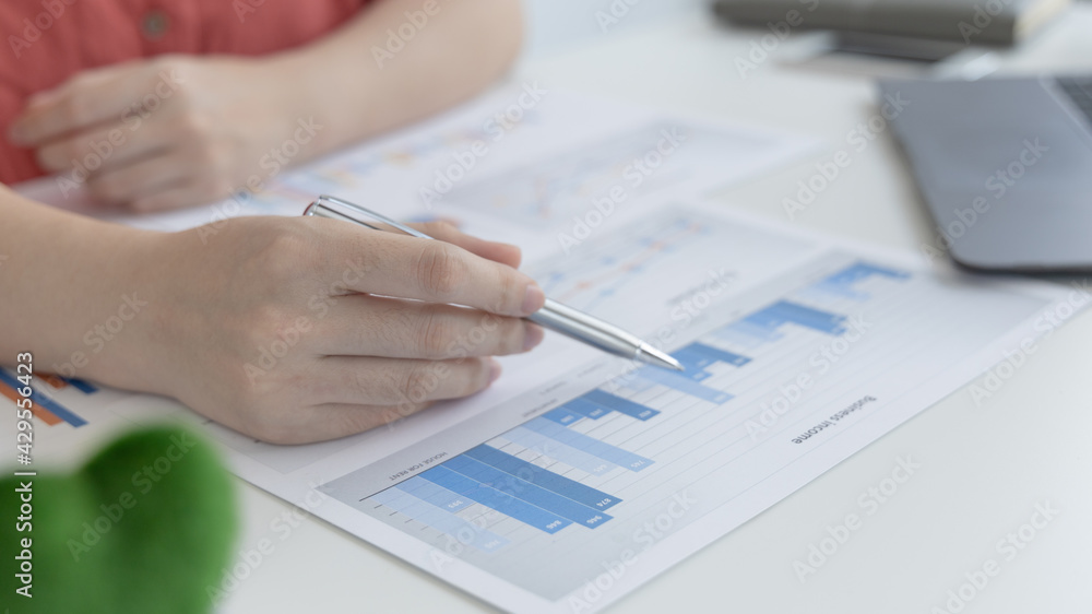 Asian women are analyzing graphs, market data and assessing investment risks, Working at home during the outbreak of the virus or social spacing, Refraining from spreading germs. Asian women are analyzing graphs, market data and assessing investment risks, Working at home during the outbreak of the virus or social spacing, Refraining from spreading germs.