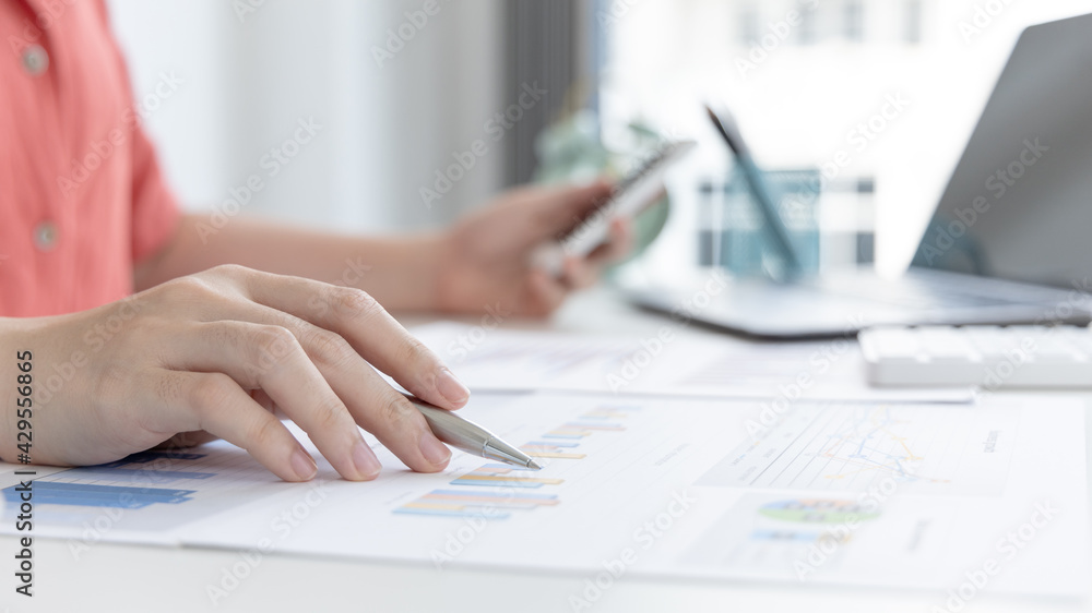 Asian women are analyzing graphs, market data and assessing investment risks, Working at home during the outbreak of the virus or social spacing, Refraining from spreading germs. Asian women are analyzing graphs, market data and assessing investment risks, Working at home during the outbreak of the virus or social spacing, Refraining from spreading germs.