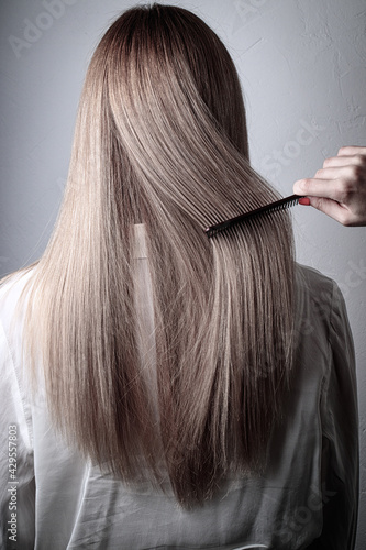Women's blonde long hair. Combing, beauty salon, hairdresser, result, procedures, coloring, style