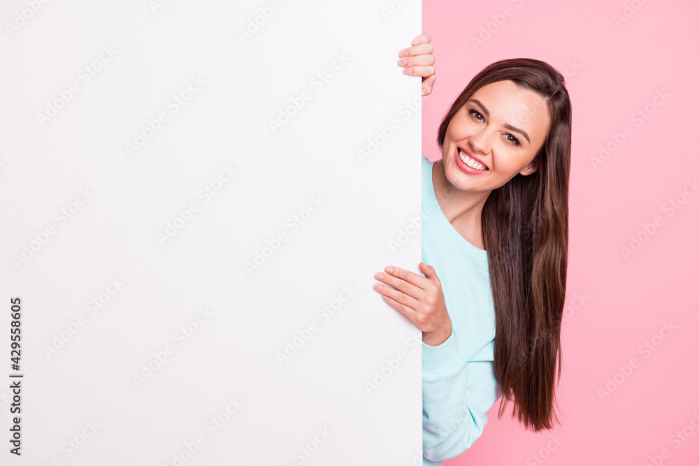 Photo of cheerful young woman hold stand white banner empty space isolated on pastel pink color background Photo of cheerful young woman hold stand white banner empty space isolated on pastel pink color background