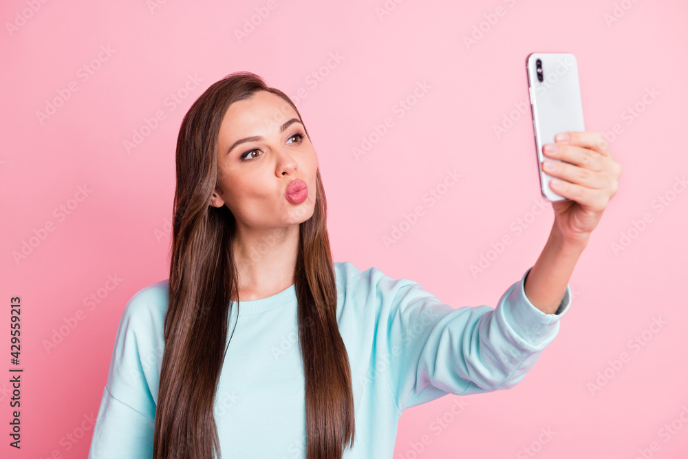 Photo of beautiful flirty young woman take photo selfie send air kiss isolated on pastel pink color background Photo of beautiful flirty young woman take photo selfie send air kiss isolated on pastel pink color background