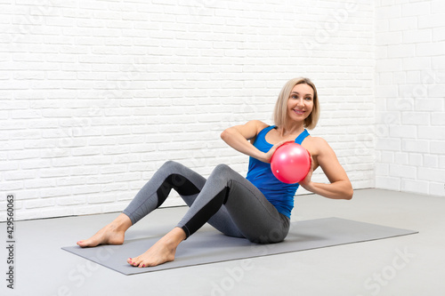 Fotografie Sitting spine twisting with small fit ball