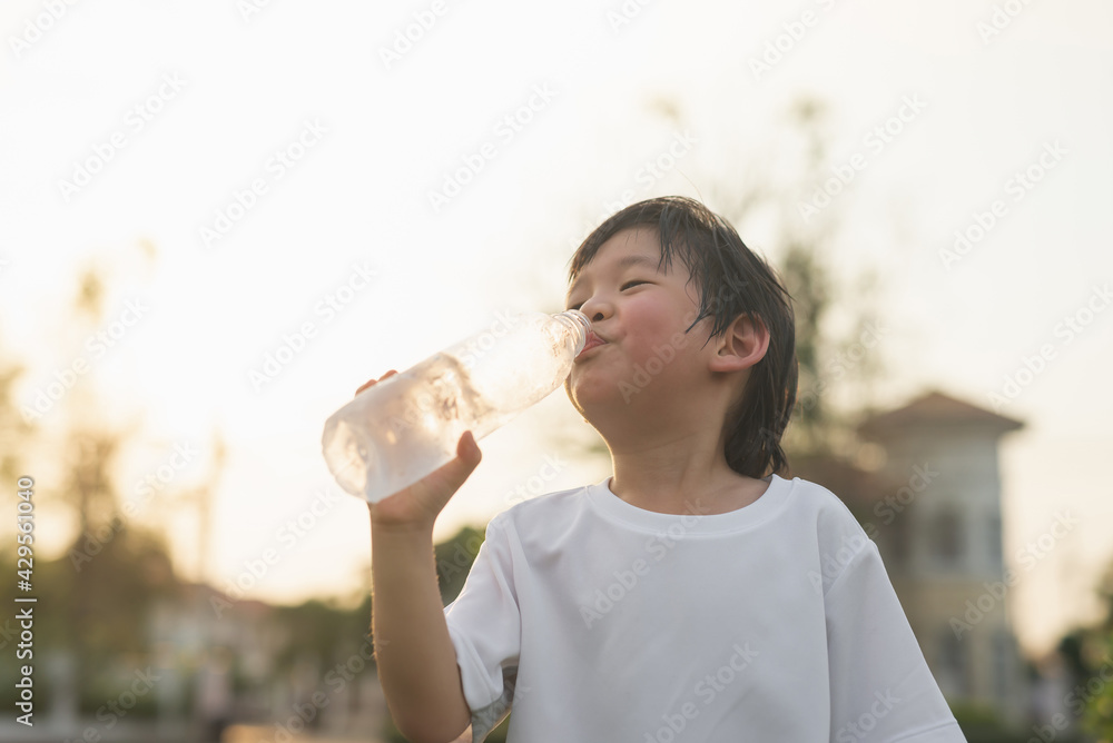 asian boy drinks water from a bottle outdoors asian boy drinks water from a bottle outdoors