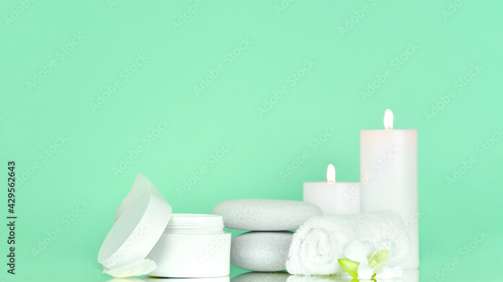 Beauty products with Towel, candles and white stone on color background. Beauty spa treatment and relax concept.