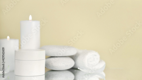 Beauty products with Towel  candles and white stone on color background. Beauty spa treatment and relax concept.