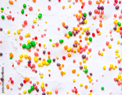 Rainbow colored candy nerds sprinkled on a white background