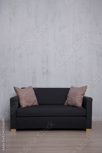 Sofa with copy space over concrete wall