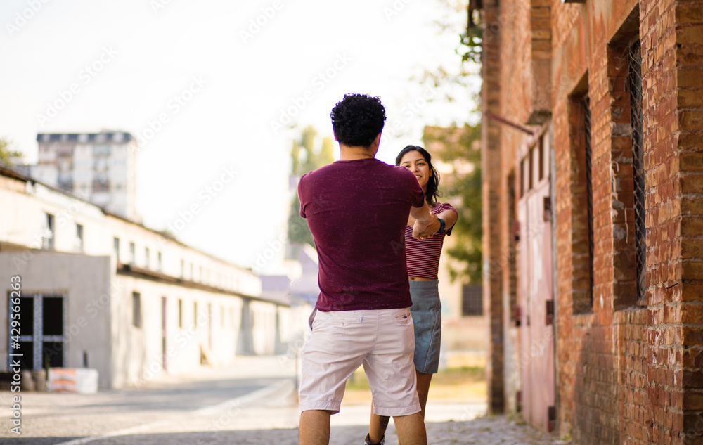 Young couple having fun on street. Focus is on man.