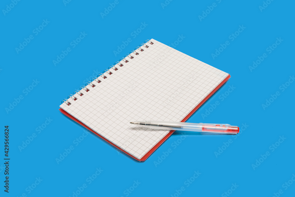 spiral notebook with a pen on a blue background spiral notebook with a pen on a blue background