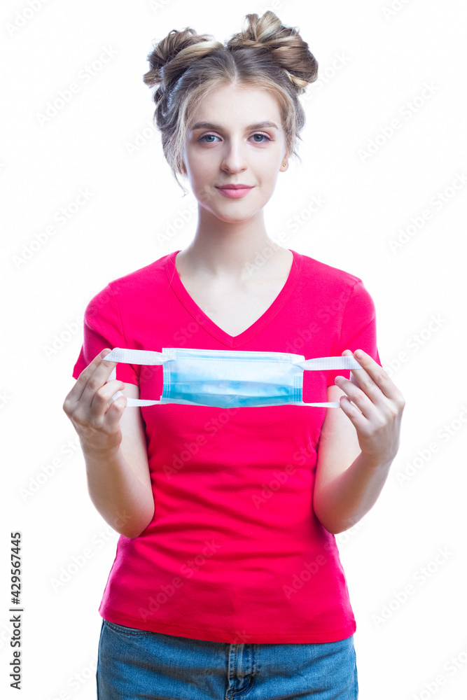 Medical Ideas. Friendly Caucasian Girl Demonstrating How To Apply Surgical Mask On Face Step By Step Against White Background. Medical Ideas. Friendly Caucasian Girl Demonstrating How To Apply Surgical Mask On Face Step By Step Against White Background.