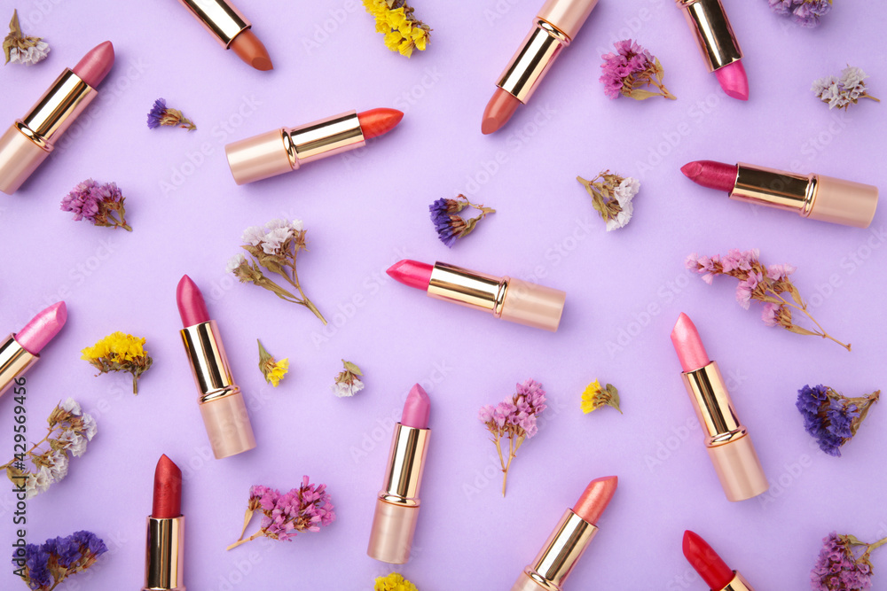 Lipstick with beautiful flowers on purple background Lipstick with beautiful flowers on purple background