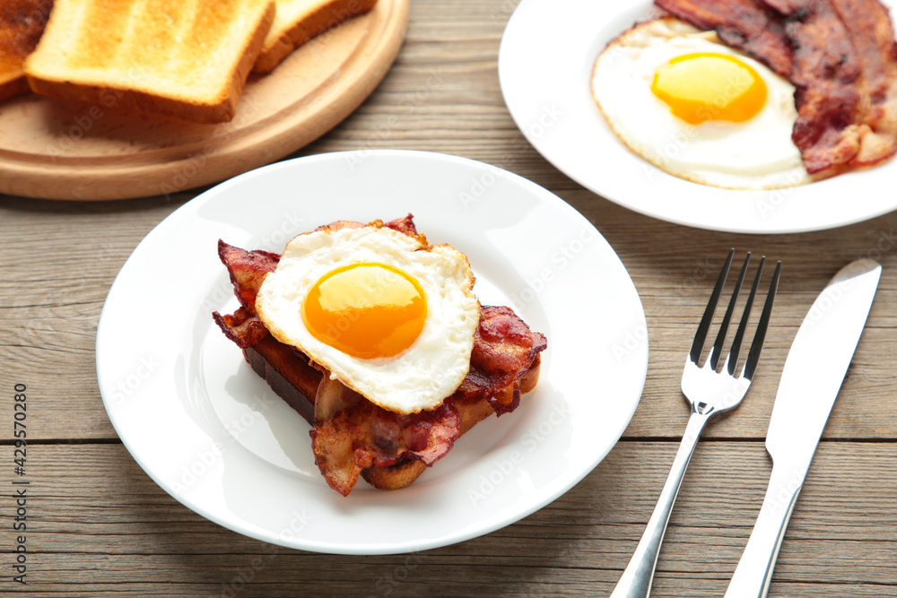 Traditional full English breakfast - fried eggs, beans, bacon and toast on grey background with copy space for text. Traditional full English breakfast - fried eggs, beans, bacon and toast on grey background with copy space for text.