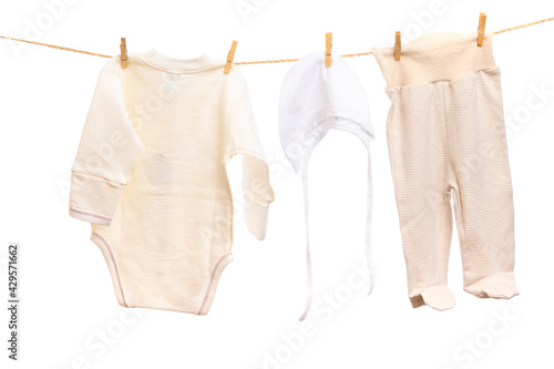 Baby clothes on a clothesline on white background