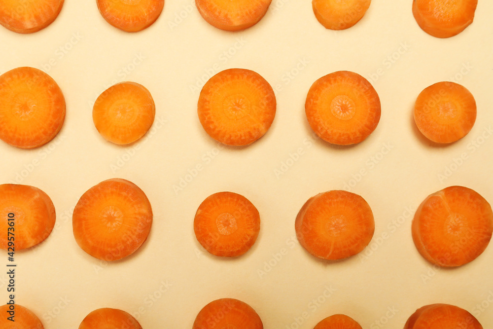 Slices of fresh carrot on beige background Slices of fresh carrot on beige background