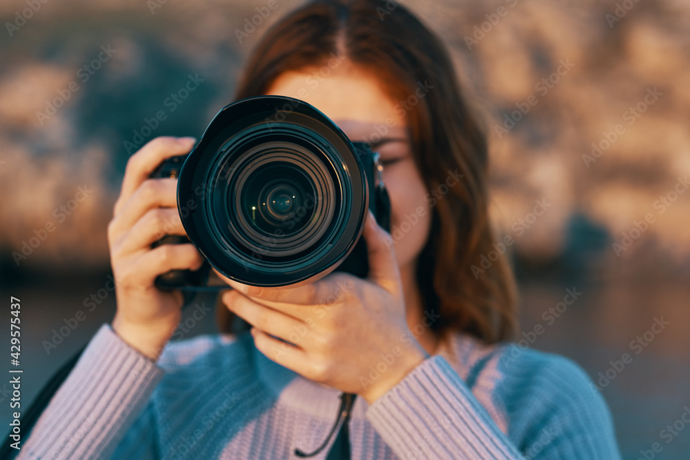 red-haired woman with a camera on nature in the mountains near the river red-haired woman with a camera on nature in the mountains near the river
