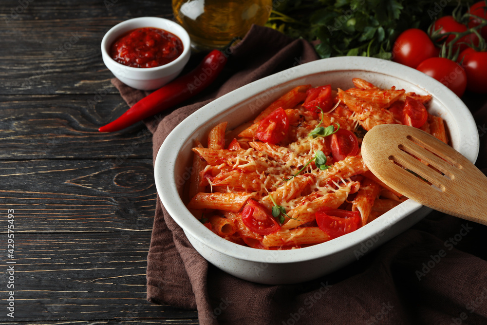 Tray with pasta with tomato sauce on wooden table, space for text Tray with pasta with tomato sauce on wooden table, space for text