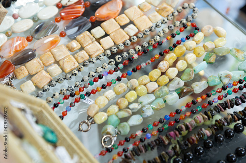Necklaces made of semiprecious stones on display of jewelry store