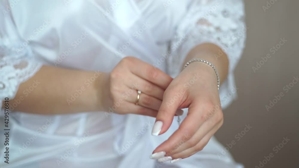The girl puts on a bracelet. Jewelry. The girl puts on jewelry. Gold jewelry. The girl puts on a bracelet. Jewelry. The girl puts on jewelry. Gold jewelry.