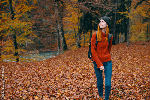 hiking travel woman with backpack on her back and fallen dry leaves nature forest park model © SHOTPRIME STUDIO