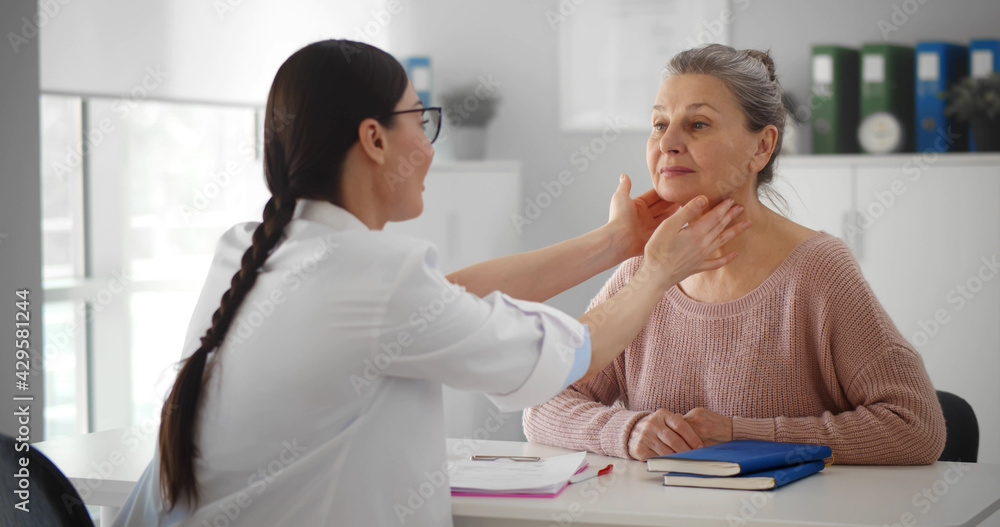 Professional physician checking neck lymph nodes of old woman Professional physician checking neck lymph nodes of old woman