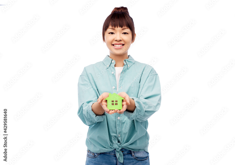 eco living, environment and sustainability concept - portrait of happy smiling young asian woman in turquoise shirt holding green house over white background eco living, environment and sustainability concept - portrait of happy smiling young asian woman in turquoise shirt holding green house over white background