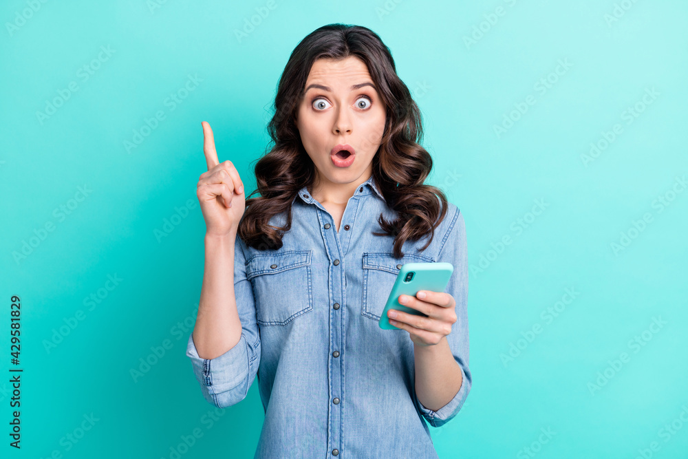 Photo of young girl point finger idea solution decision use cellphone isolated over turquoise color background Photo of young girl point finger idea solution decision use cellphone isolated over turquoise color background