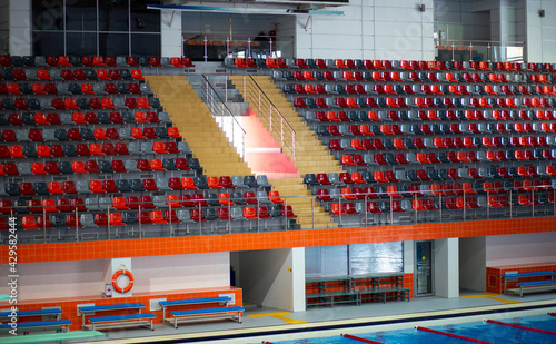empty bleachers plastic chairs in a large sports pool for swimming and diving